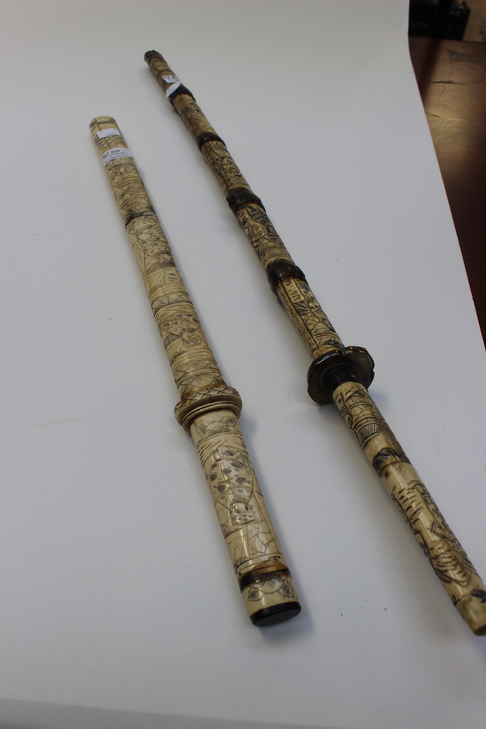 A pair of Oriental swords in carved bone scabbards