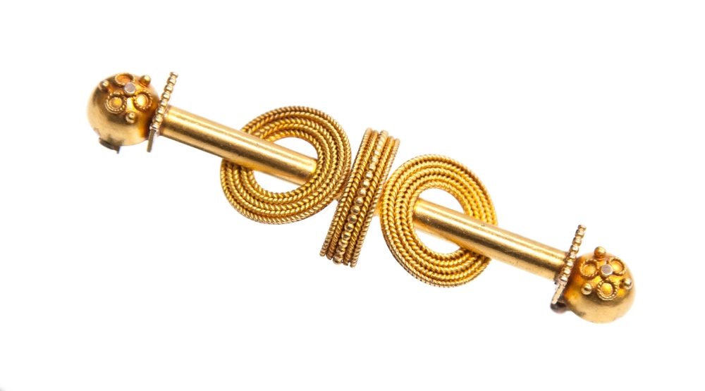 An Etruscan Revival yellow metal brooch, circa 1870, of bar form with ropework disks, 5cm long, 6.