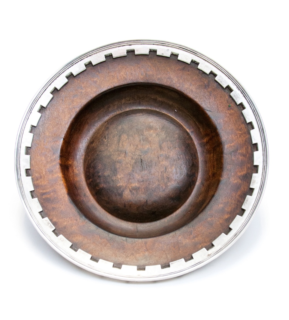 Omar Ramsden, an Arts and Crafts silver banded burr wood dish, of circular form with crenellated