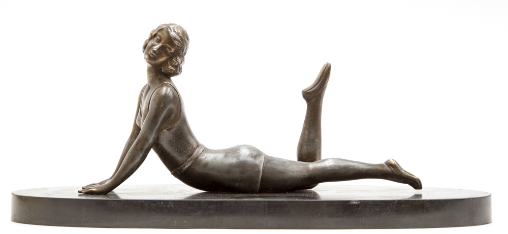 An Art Deco bronzed and silvered figure of a bather, circa 1930, reclining on a black marble base,