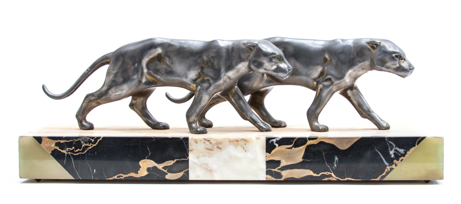An Art Deco silvered figure of two panthers, on a variously coloured marble and green onyx base,
