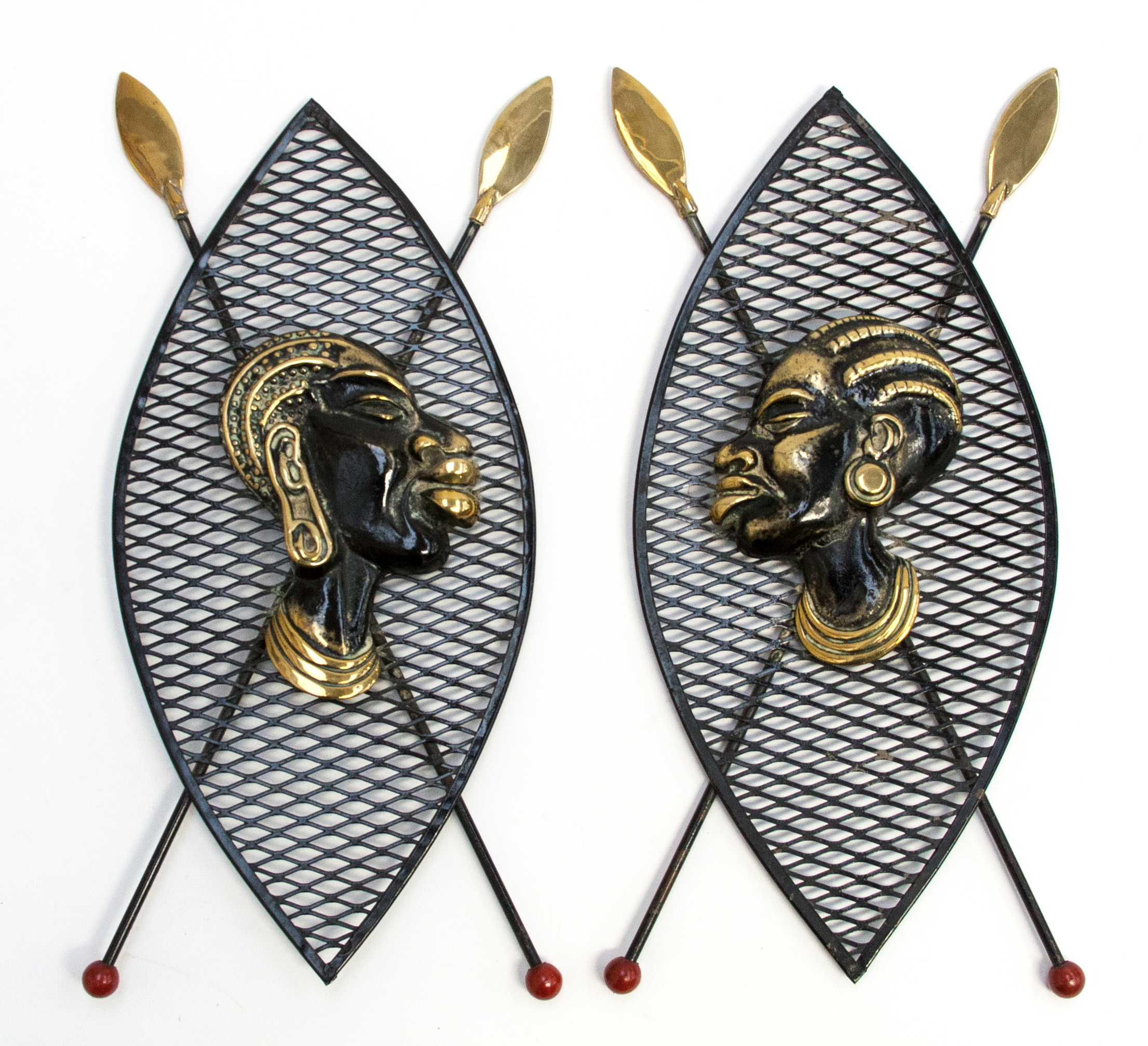 A pair of 1950s African design wall plaques in the form of Zulu shields and crossed shields with