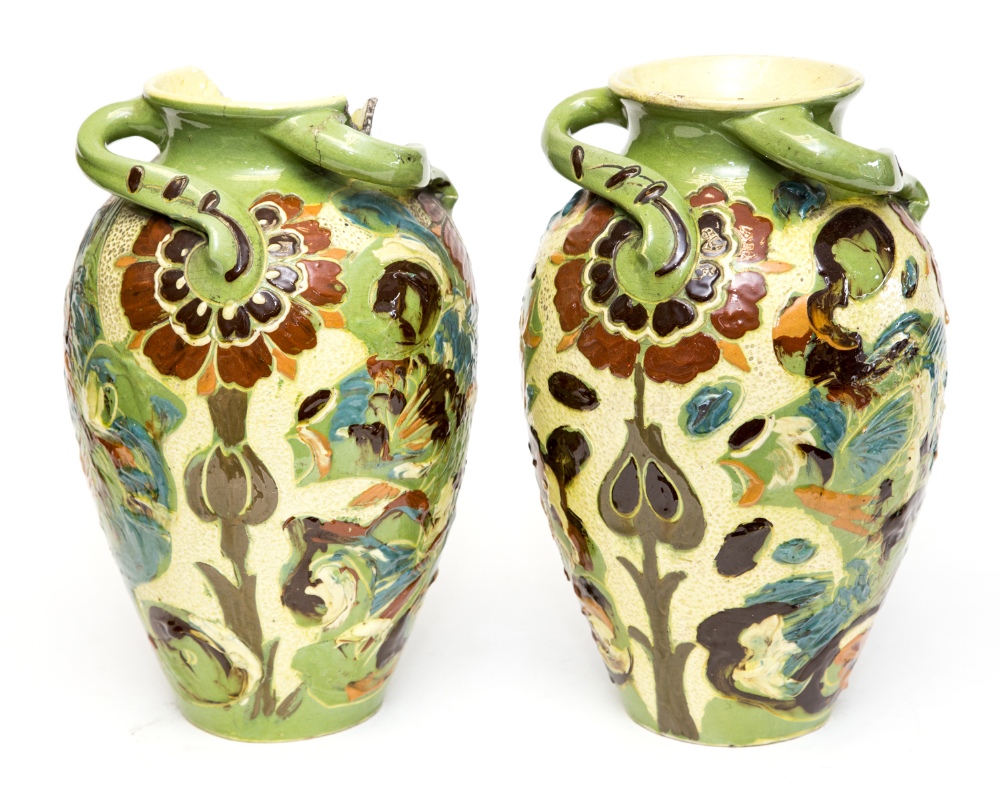 A pair of C H Brannam Arts and Crafts vases, of ovoid form with wrythen handles, incised with Art