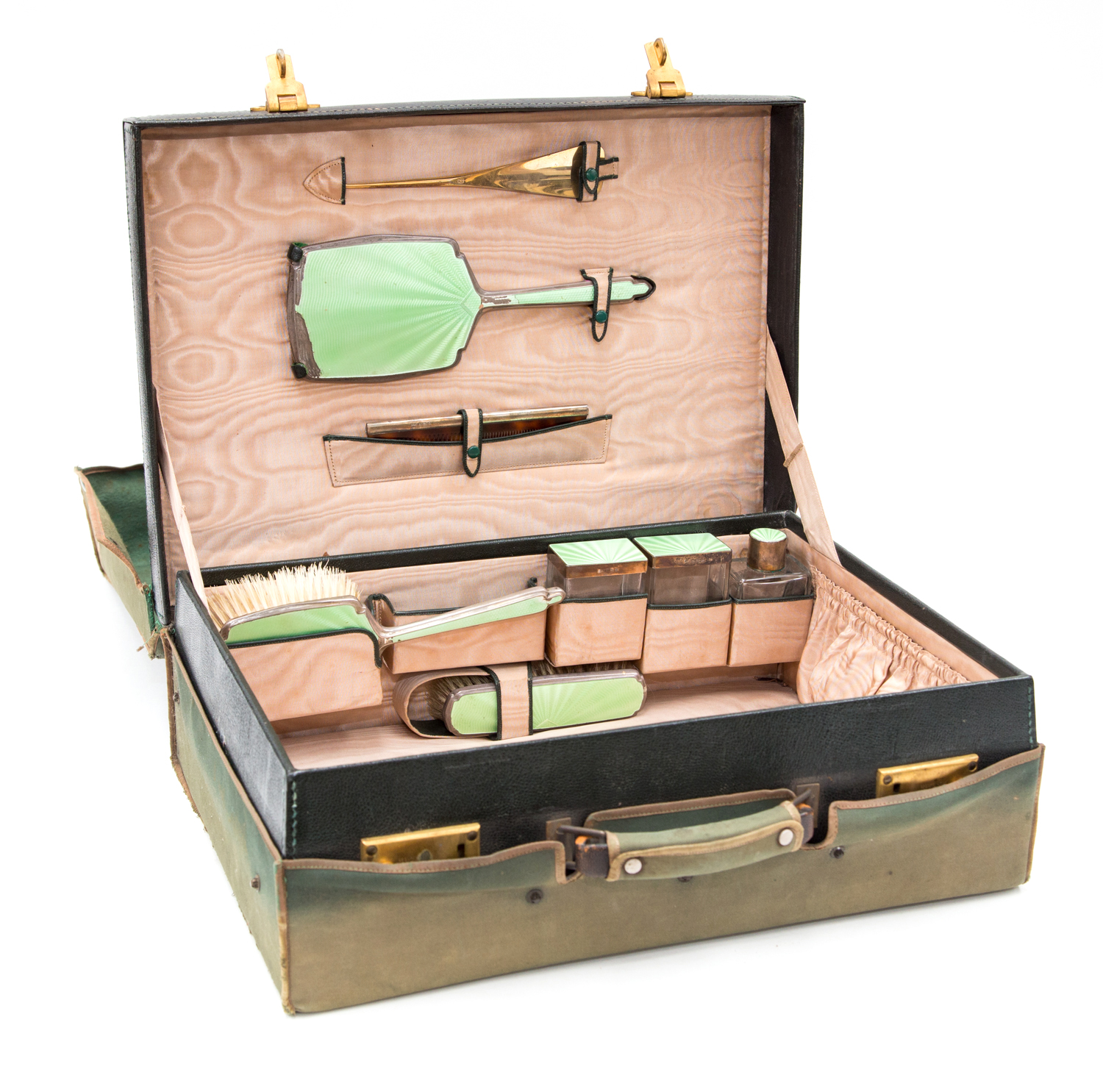 An Art Deco travelling toilet set, green guilloché enamelled silver brushes and bottles in a green