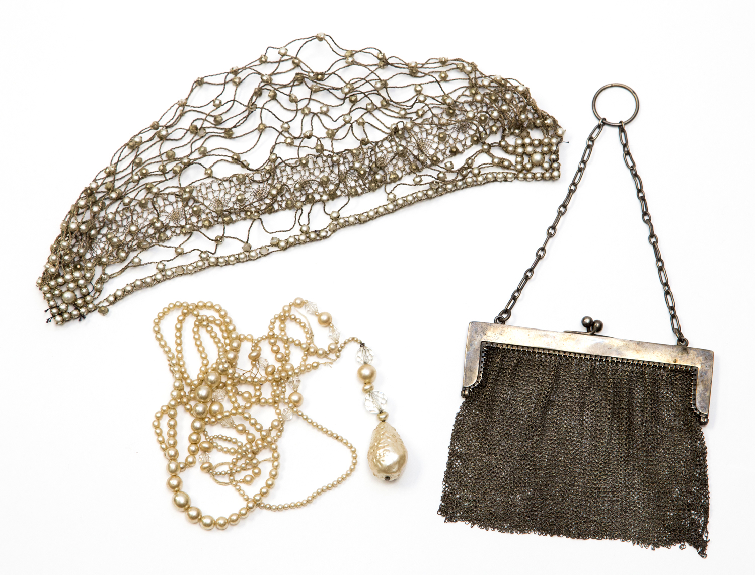 A 1920s skull cap, silvered wire and faux half pearls, together with a simulated pearl necklace