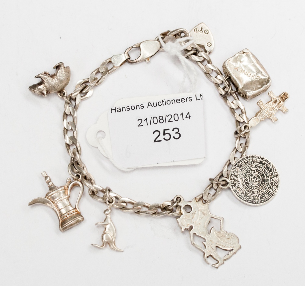 A silver charm bracelet with Australian and other charms.