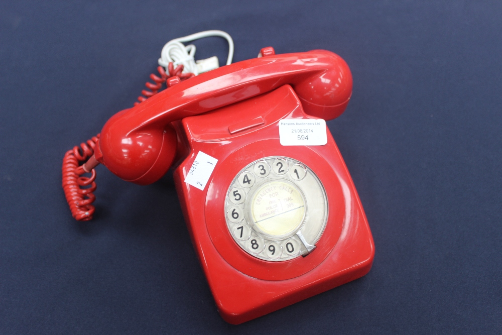A red 700 series telephone in working order