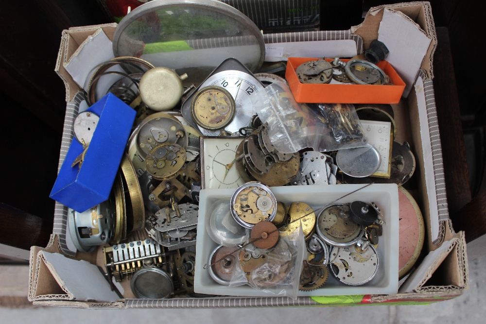 A box containing a collection of pocket watch parts, etc.