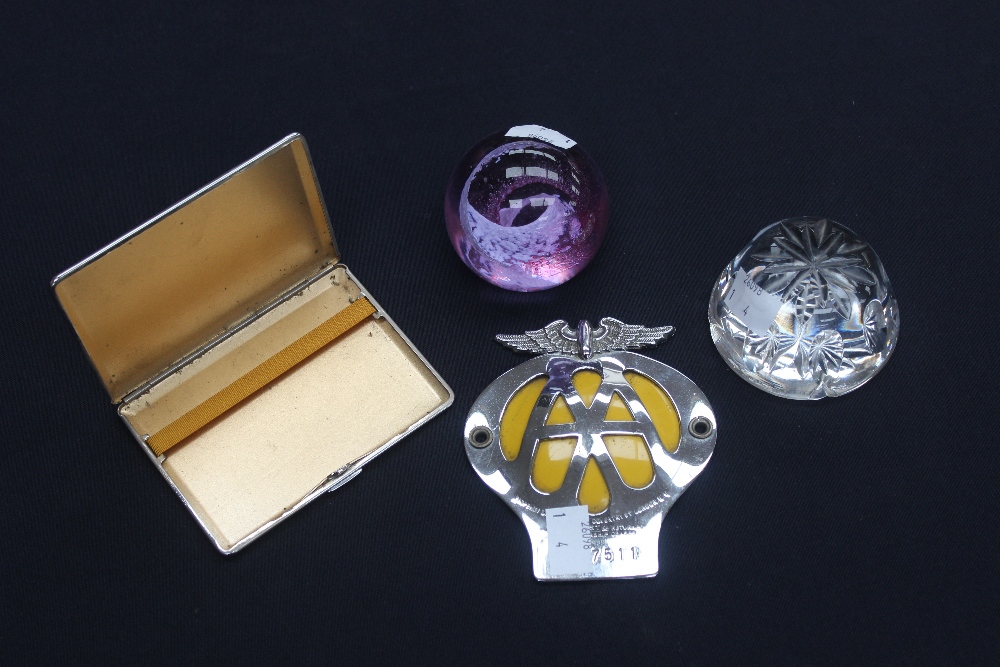 A pair of glass paperweights, plated cigarette case and a vintage AA badge.