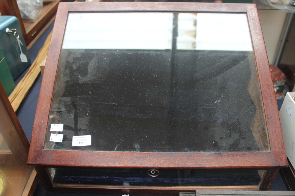 A mahogany stained table top display case with a tiered lined interior