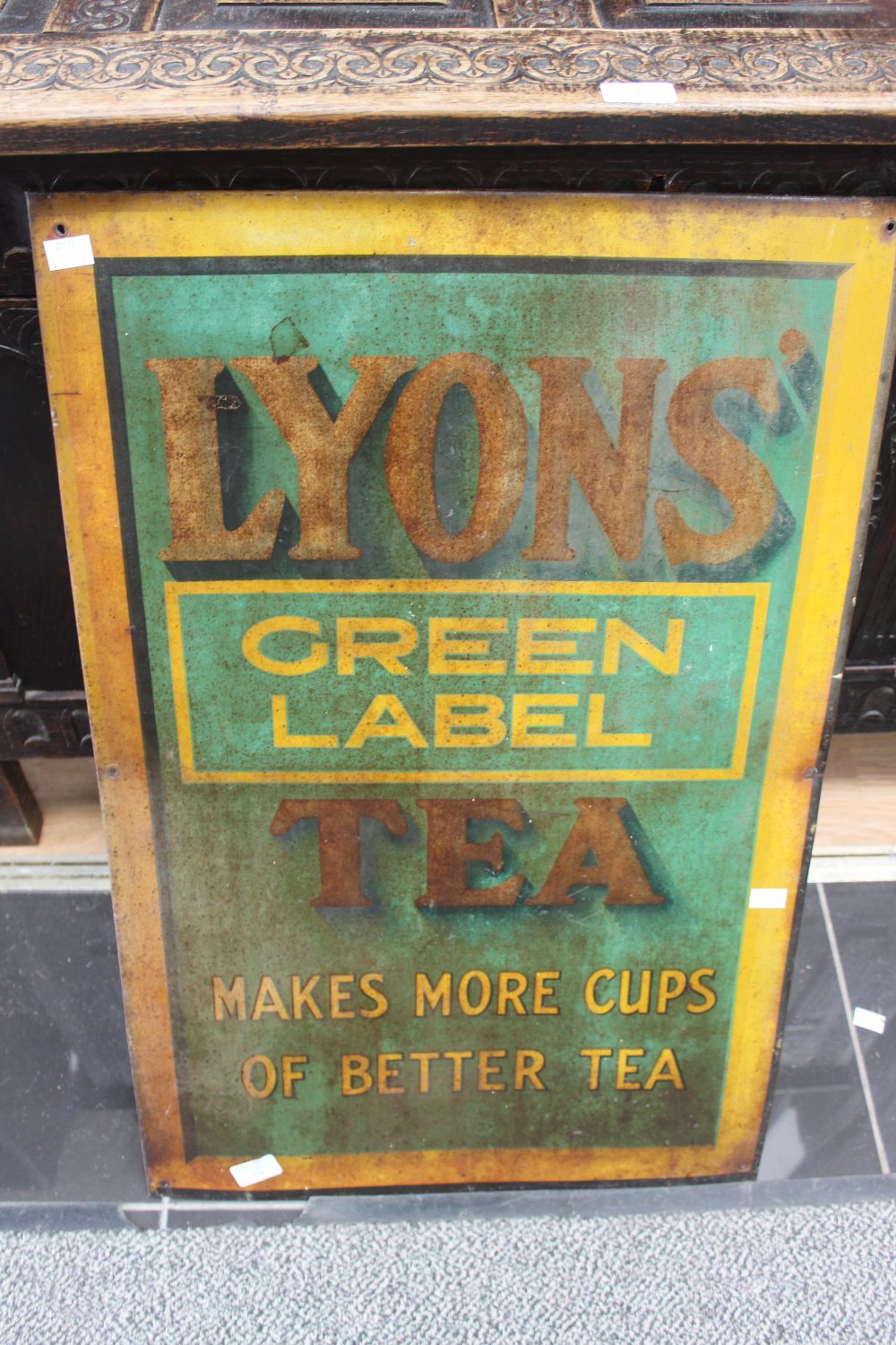 An early 20th Century enamel sign for Lyons tea 'Green Label; makes more cups of better tea.' 76cm x