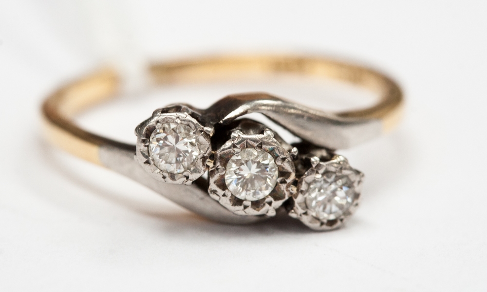 A crossover three stone diamond 18ct gold and platinum setting diamonds approx 0.24 ct in total