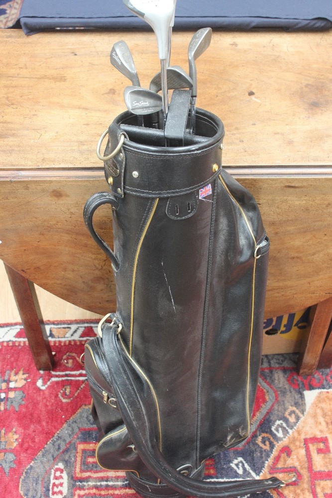 A collection of gold clubs in carrying case