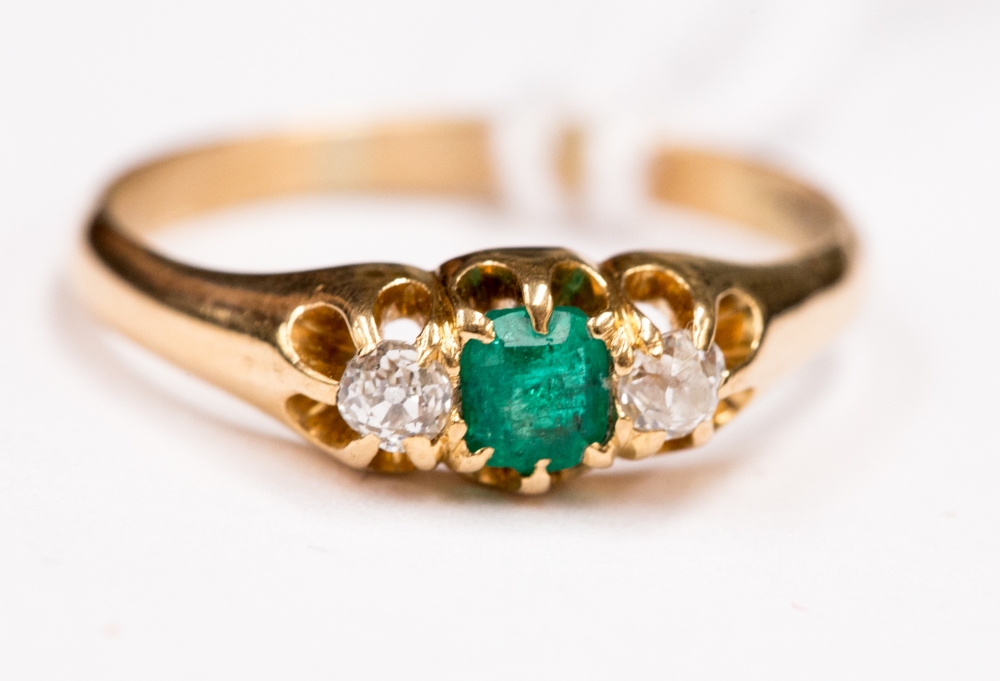 An 18k gold, emerald and diamond three - stone ring, size O