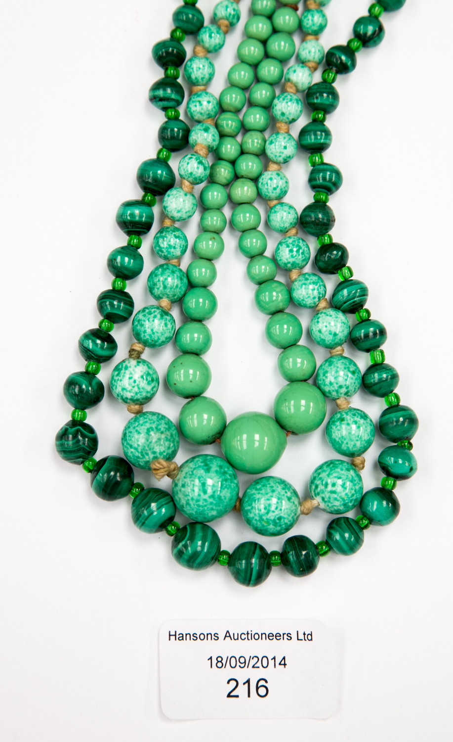 A malachite bead necklace; two green glass necklaces