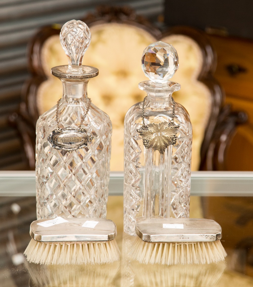 A pair of silver backed hair brushes; together with a cut glass decanter with silver rim and