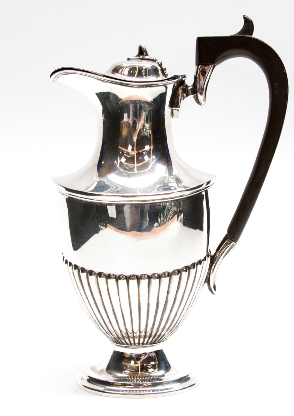 A George V silver hot water jug, of NeoClassical form with reeded lower section and ebony handle,