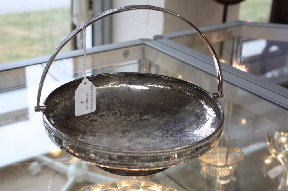 A George V silver circular swing handled basket, handle cast with geometric and egg design, the