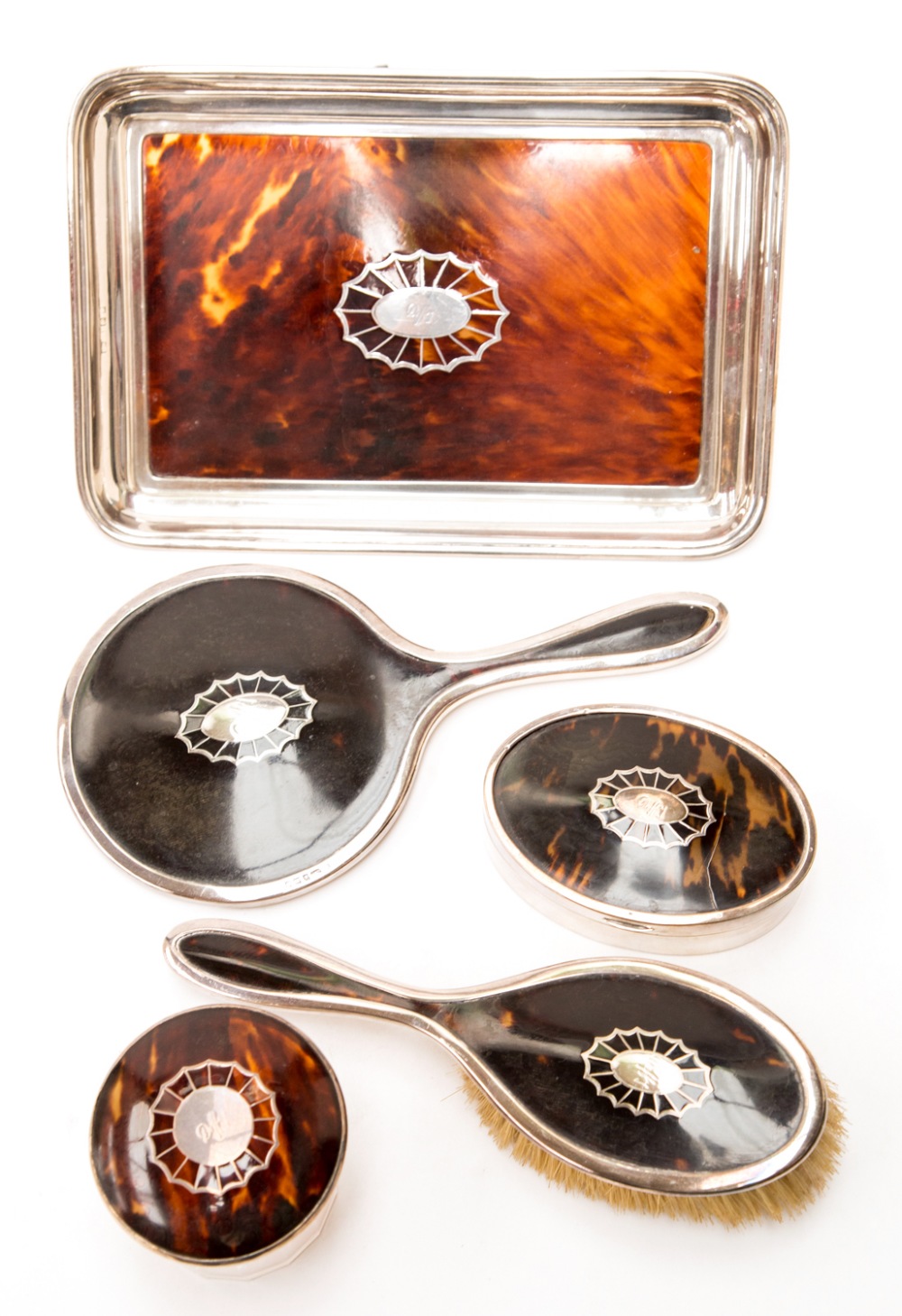 A George V silver and tortoiseshell dressing table set including tray , brush, hand mirror, silver