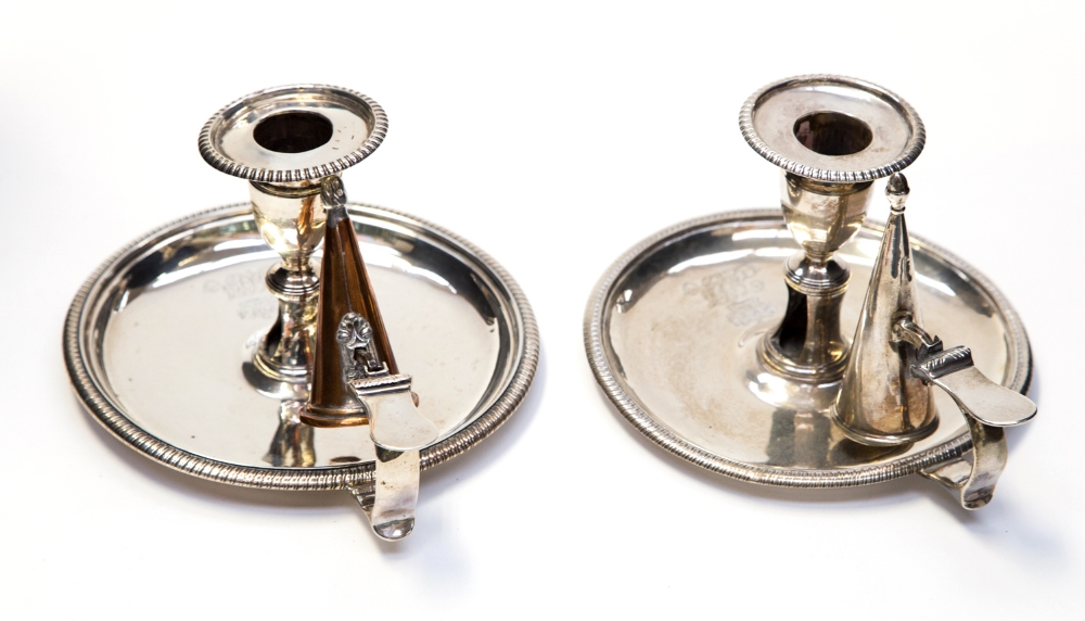 A matched pair of George III silver chamber sticks, one with original snuffer, of neoclassical