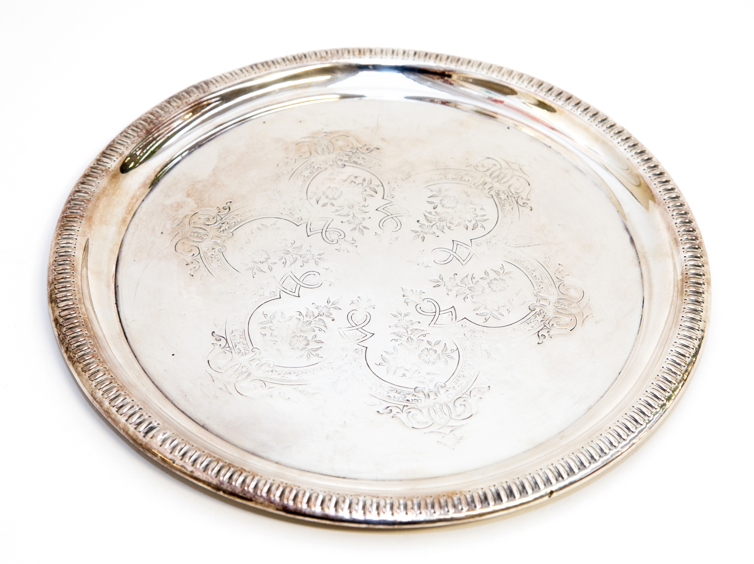 A white metal tray, circular form with egg and dart border, the centre etched with lobed cartouche