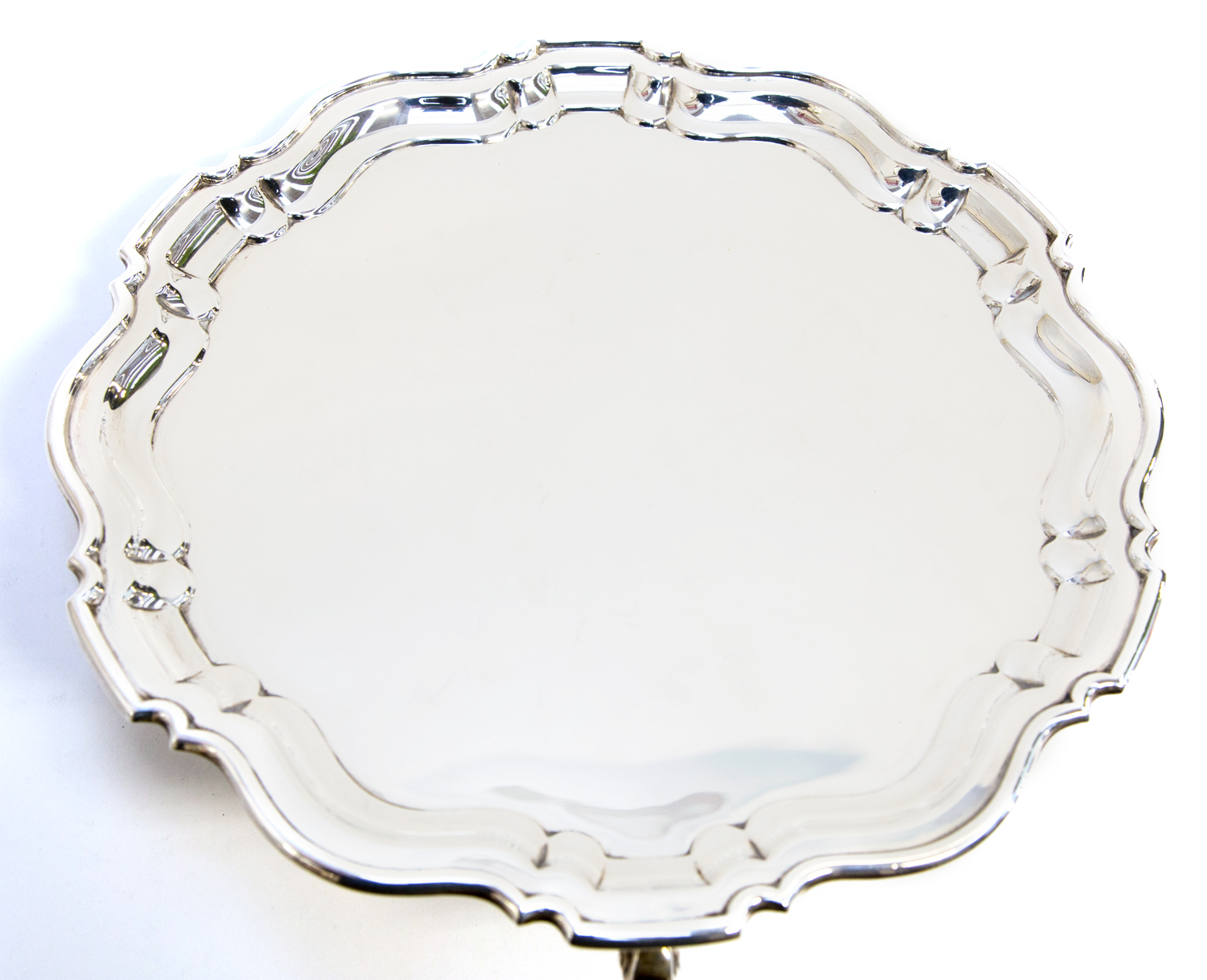 A George V silver salver, of heavy gauge with pie crust border, on four scroll feet, Blackensee
