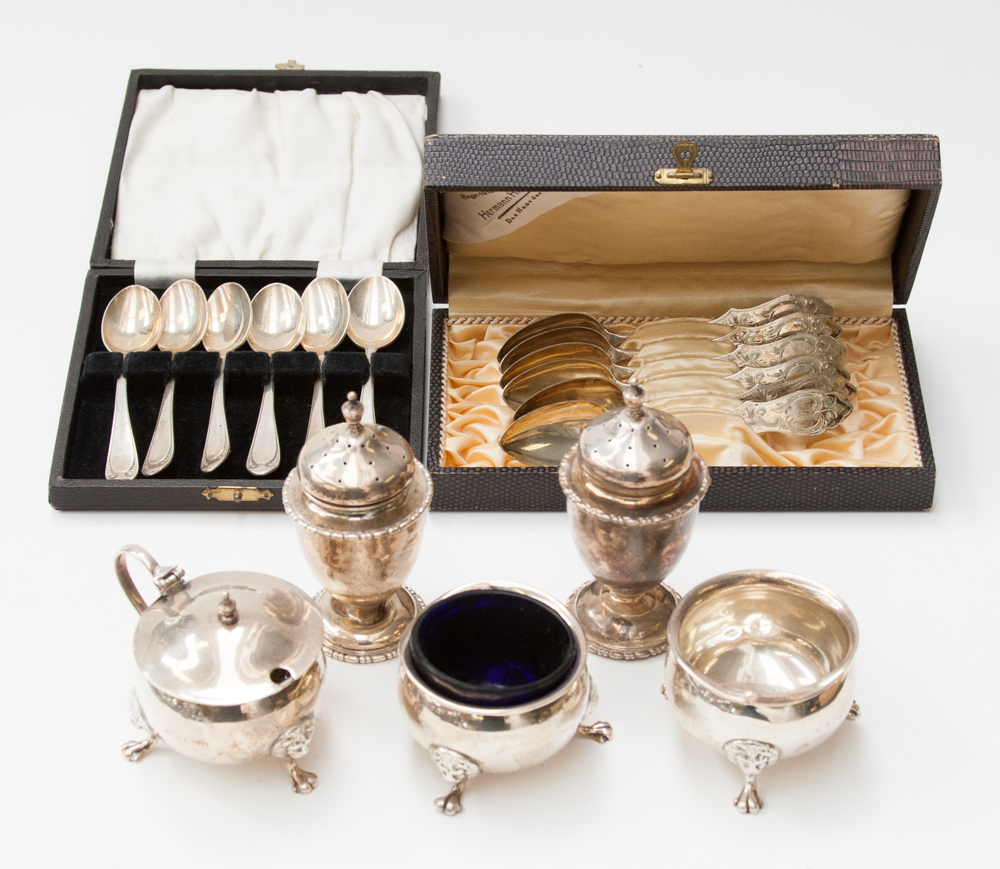 A cased set of six silver teaspoons, six continental cased spoons; silver three-piece cruet; a