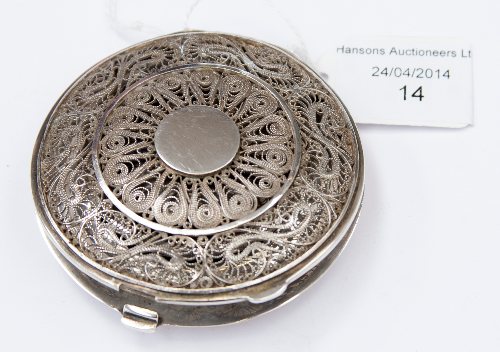 A white metal powder compact, having a filigree lid and a scene to the reverse and inner cover