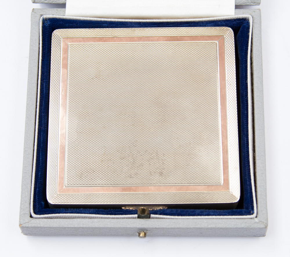 A cased 20th century Harrods silver and gilt engine turned compact, in grey box