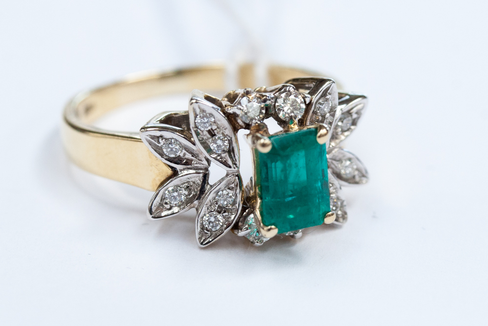 An emerald and diamond ring, the claw-set square-cut emerald, approx 0.75ct in leafage mount, set