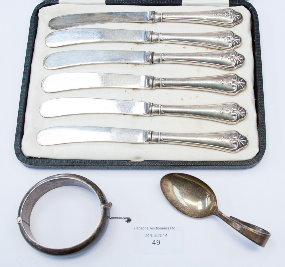 A set of silver handled tea knives, a boxed feeding spoon and a silver bangle