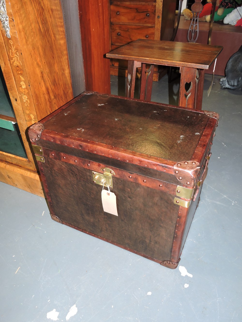 A pair of vintage style brass mounted, tan leather steamer trunks, with hinged tops and strap handle