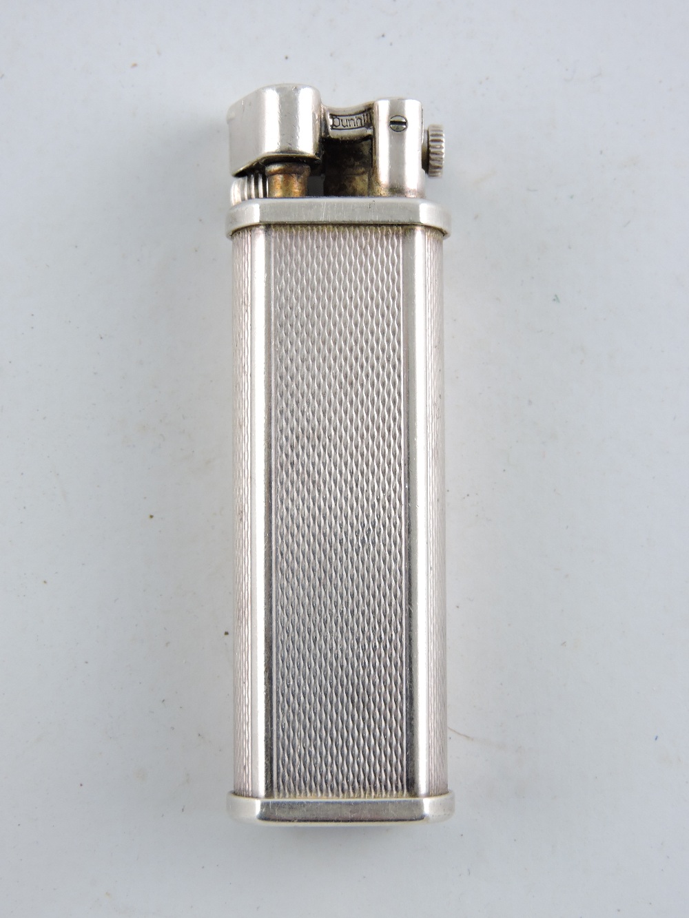 A Dunhill Sylphide lighter, silver-plated with engine turning, H. 6.5cm.