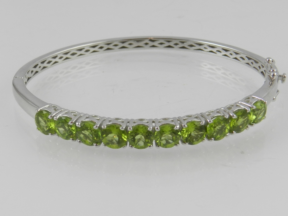 A white metal and peridot set snap bracelet, marked 925.