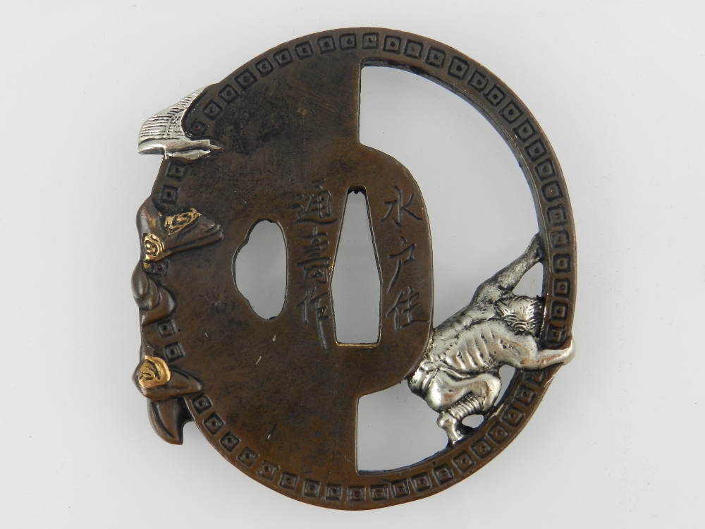 A Japanese cast bronze Katana Tsuba, decorated with an elderly man and a devil, bears script to - Image 2 of 2