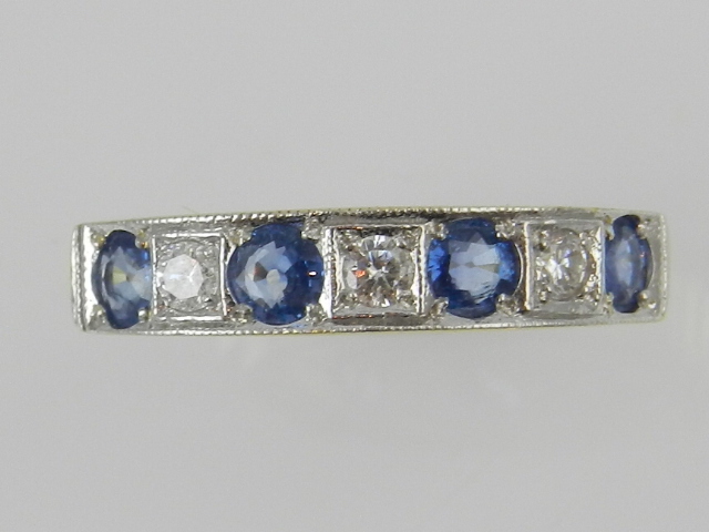 An 18ct yellow gold seven stone sapphire and diamond set dress ring.