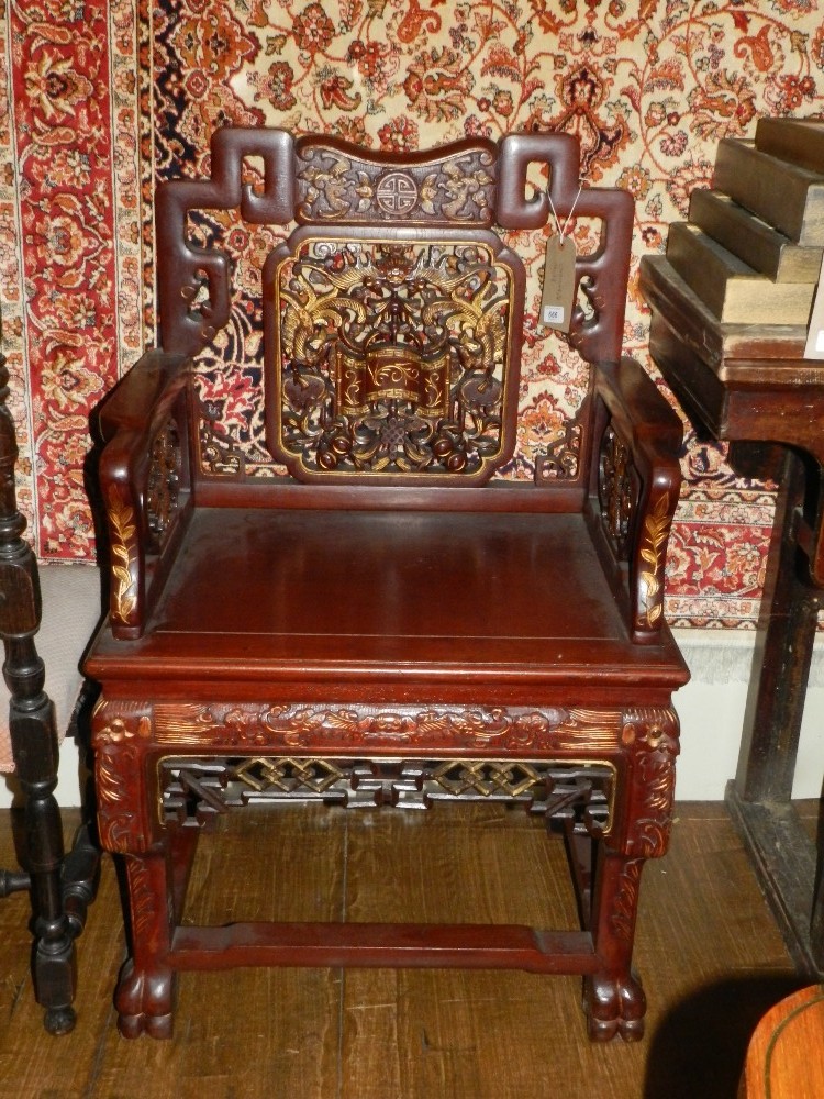 A pair of Chinese parcel gilt and red painted throne chairs, having phoenix and leaf carved and