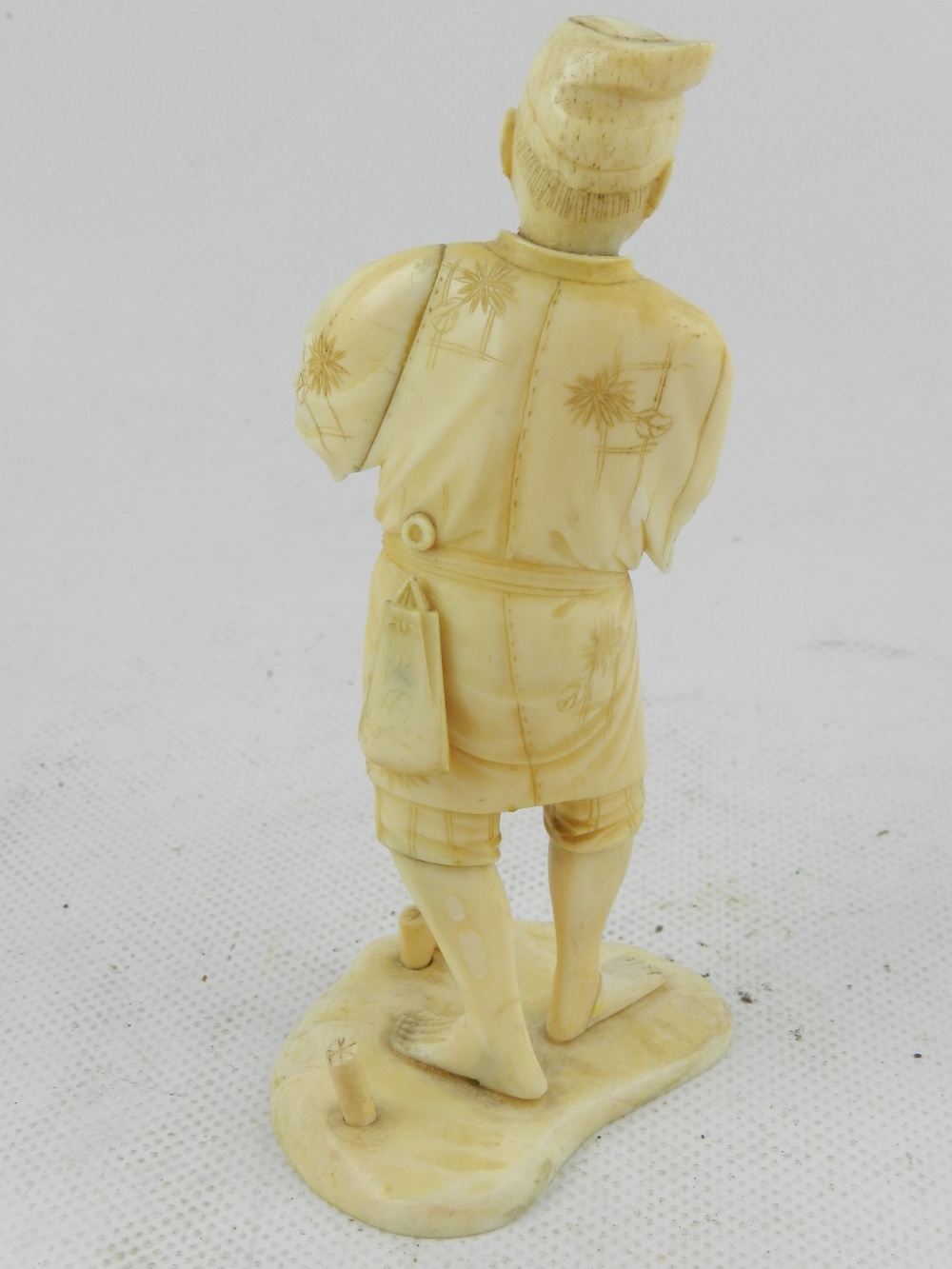 A Japanese Meiji period carved ivory okimono, study of a pastoral gentleman on naturalistic base. - Image 2 of 3