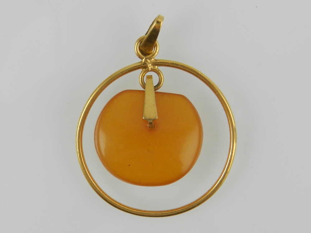 A yellow metal and amber pendant in the Modernist style, stamped 14k.