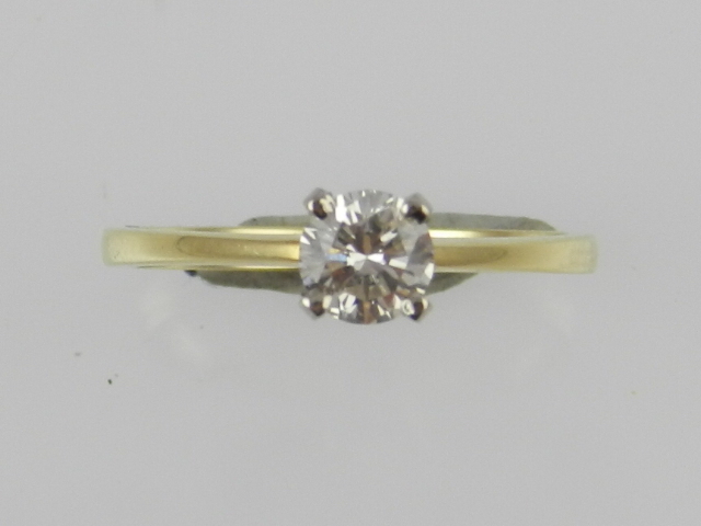 An 18ct yellow gold solitaire diamond ring, claw set with a round cut diamond.