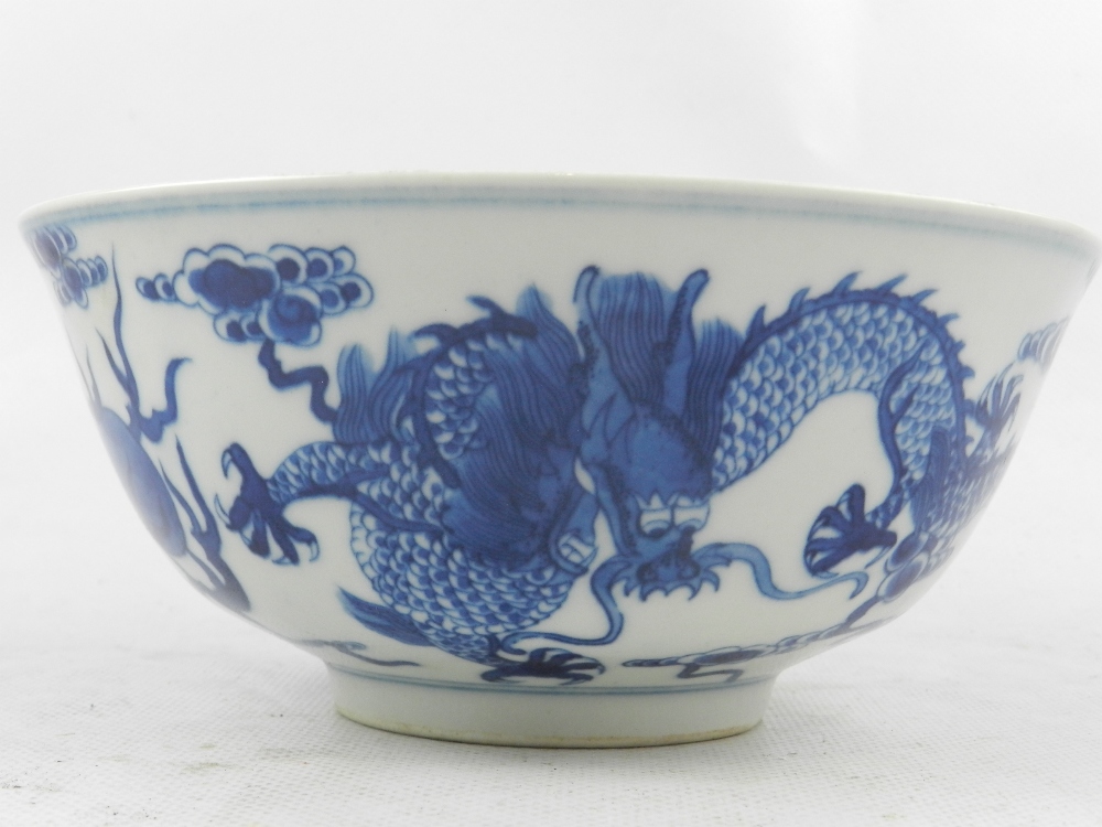 A Chinese blue and white porcelain bowl, raised on rim foot, decorated with studies of dragons
