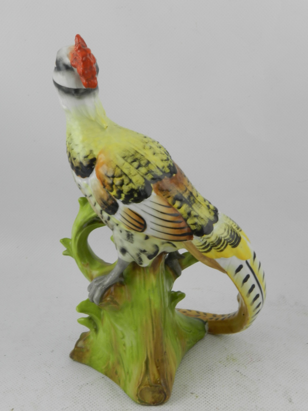 A mid 20th century German hard paste porcelain study of an exotic bird, raised on a tree stump. H: - Image 2 of 3