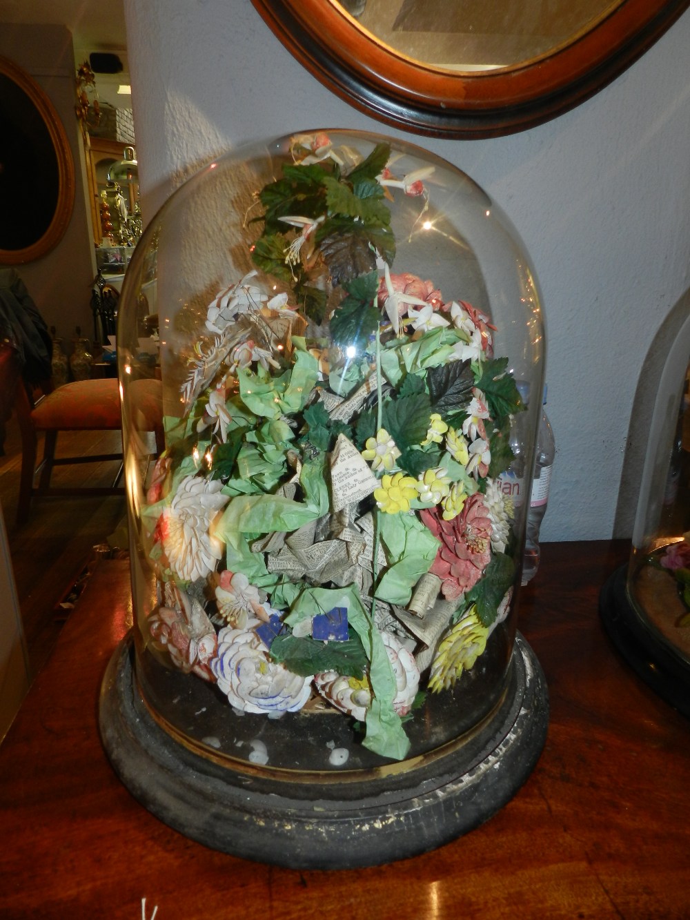 A Victorian mixed media painted shell work and paper floral arrangement within a glass dome,