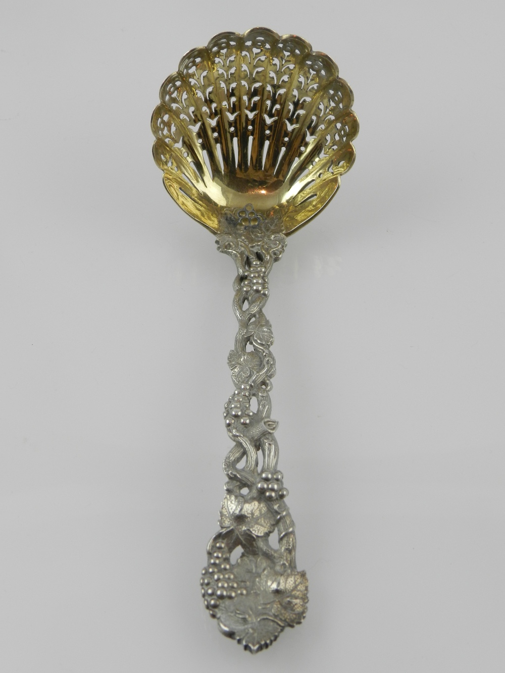 A fine Victorian silver and silver gilt sifter spoon, with vineous cast handle and terminal, and