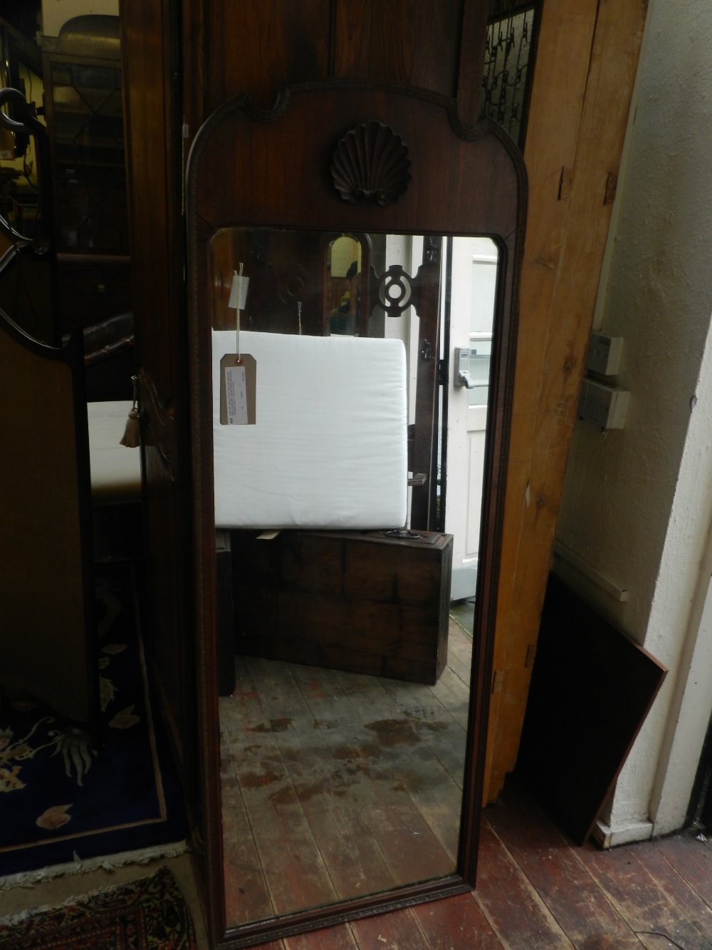 A late 19th century French walnut pier glass, the frieze mounted with a carved scallop shell above a