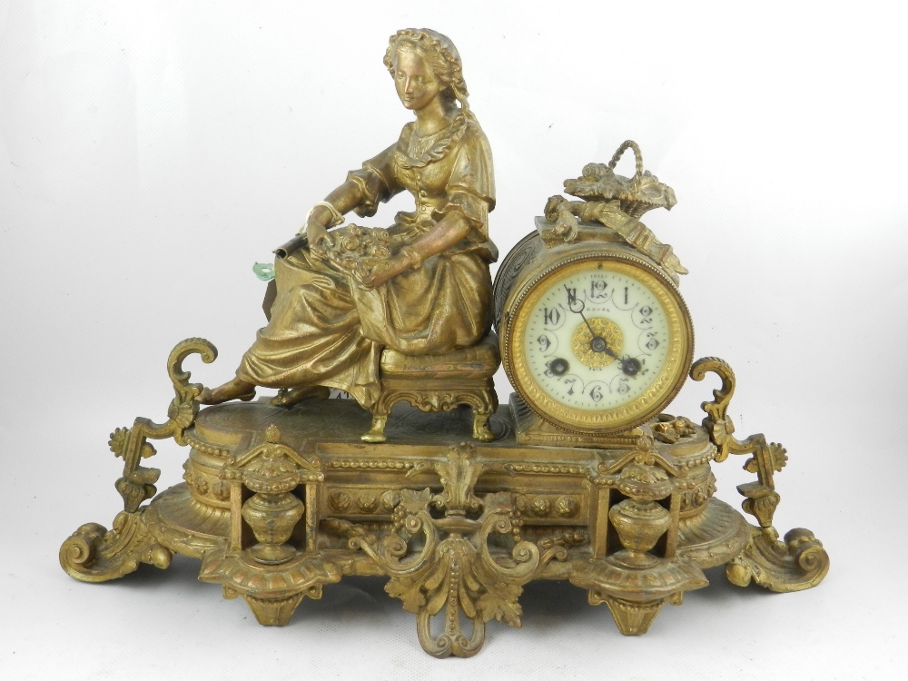 A 19th century gilt spelter figural mantel clock, the architectural case surmounted with a young