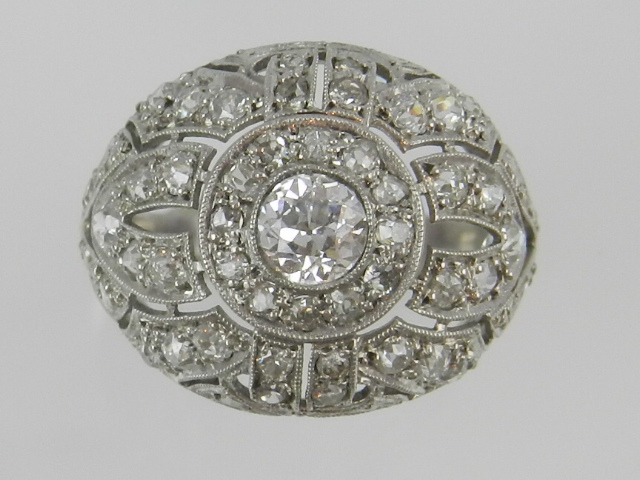 An unusual white metal and diamond dress ring, set central stone of approx. 0.3 carats