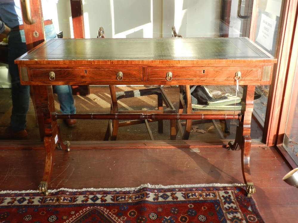 A Regency style rosewood library table, having a gilt tooled green leather skiver to top, above