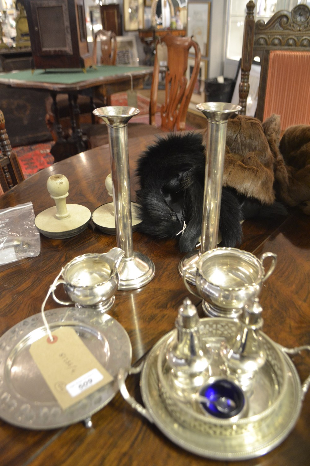A collection of silver plate items to include candle sticks, cruet set, creamer, two dishes.