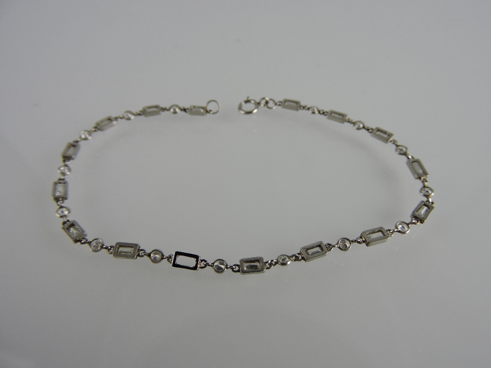 A fine link diamond line bracelet, of alternate bright and baguette cut stones linked within white